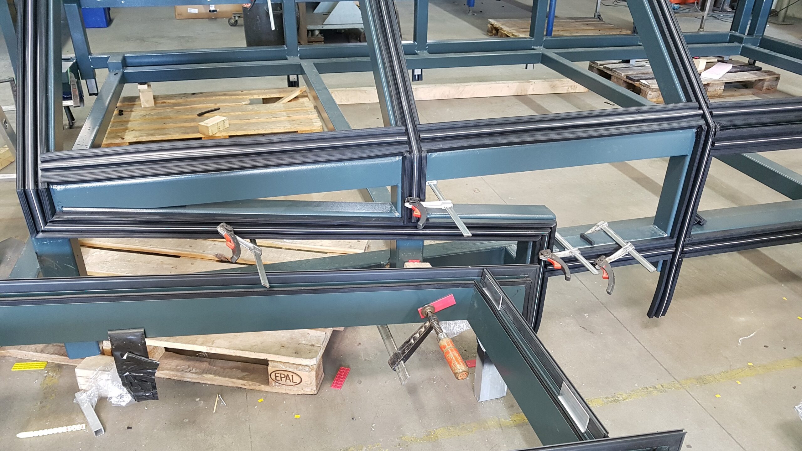 Werkstattmontage der Fassadenunterkonstruktion Vormontierte Fassadenunterkonstruktion aus Stahl- und Aluprofilen in der Werkstatt.