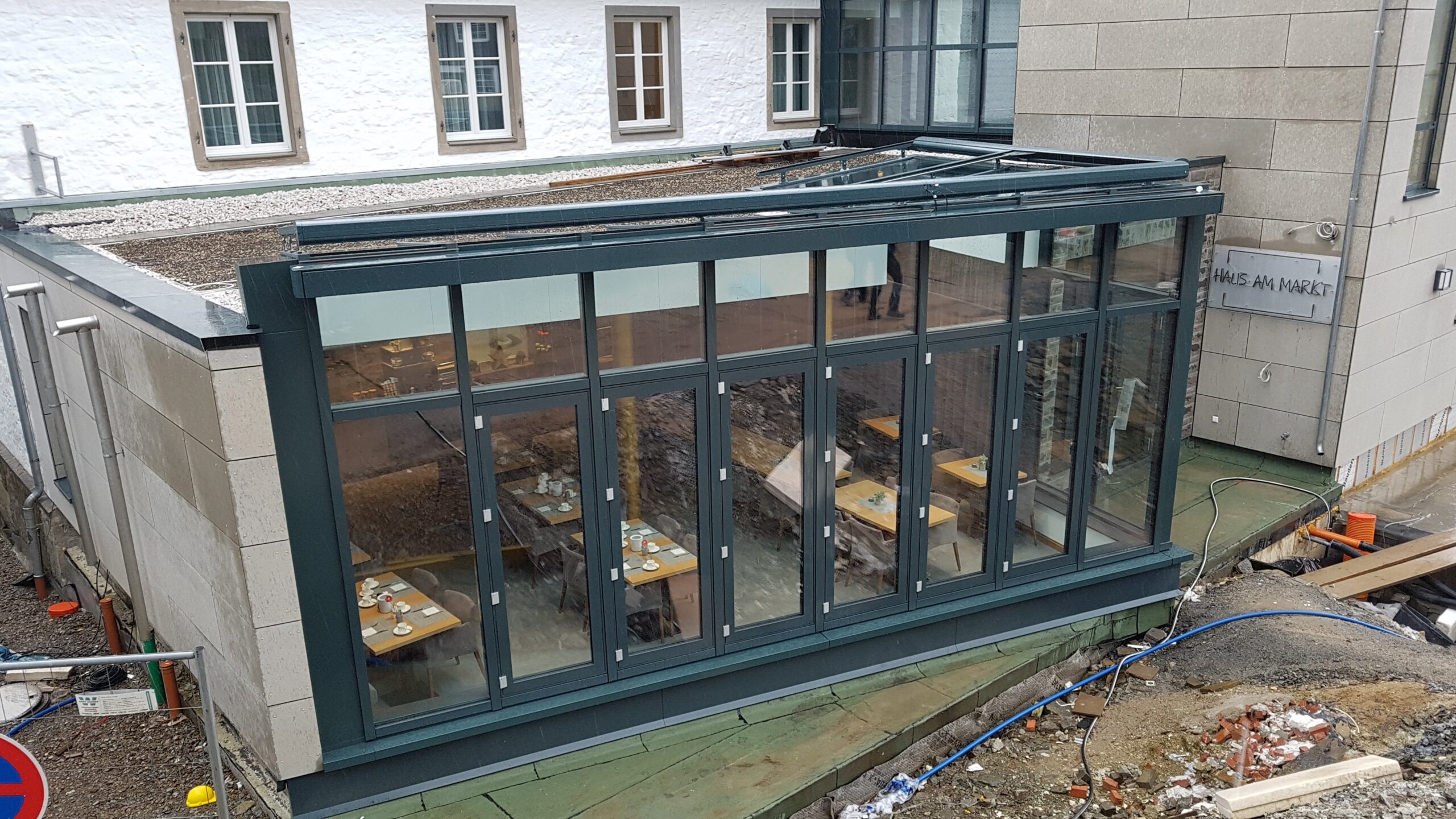 Große Glasfassade eines Anbaus, mit Faltschiebetüren und kompletter Unterkonstruktion.