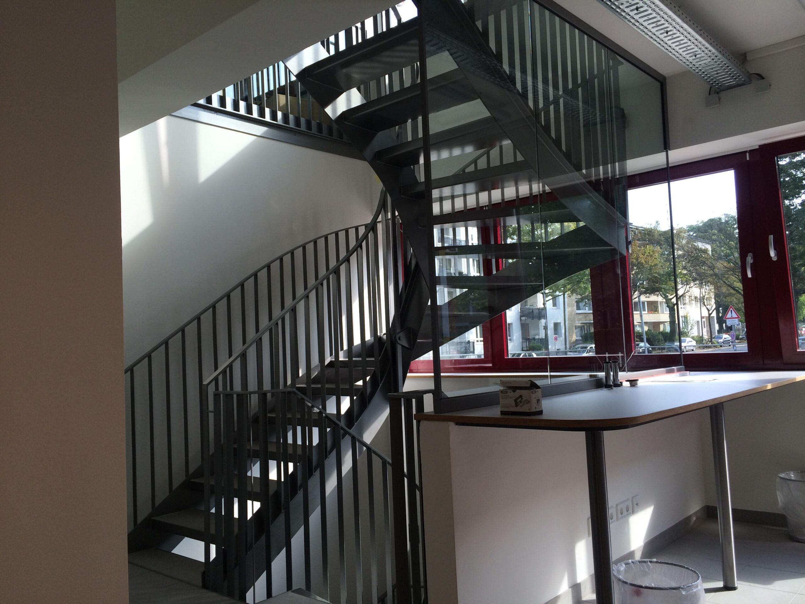 Gewendelte Innentreppe aus Flachstahl Gewendelte Innentreppe mit Wangen, Geländer und Handlauf aus Flachstahl in einem Geschäftsgebäude